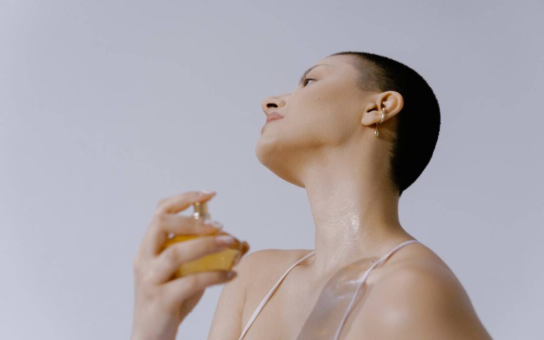 woman spraying perfume on neck